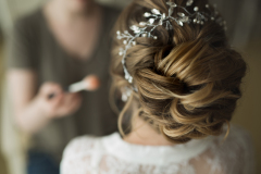 makeup artist preparing bride before the wedding in a morning.